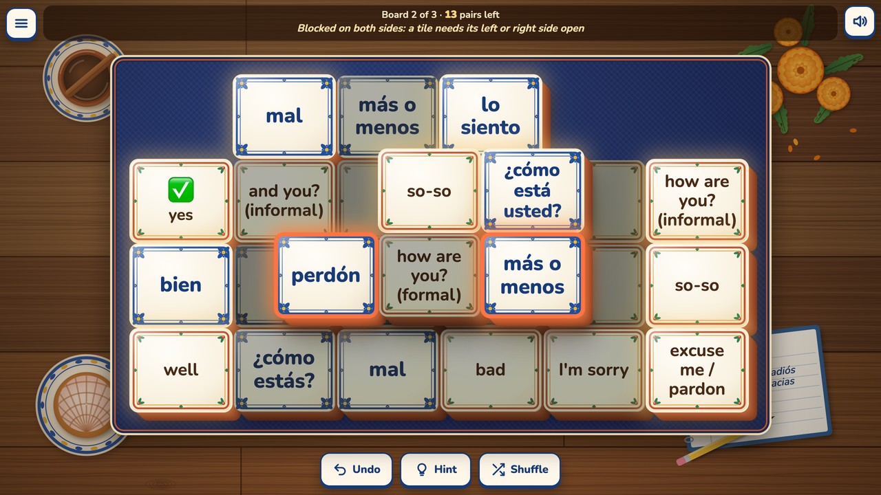 Board 2 with 13 pairs left: the blocked tile how are you? (formal) was tapped, the two tiles on either side of it, perdón and más o menos, glow orange, and the status bar says Blocked on both sides: a tile needs its left or right side open.